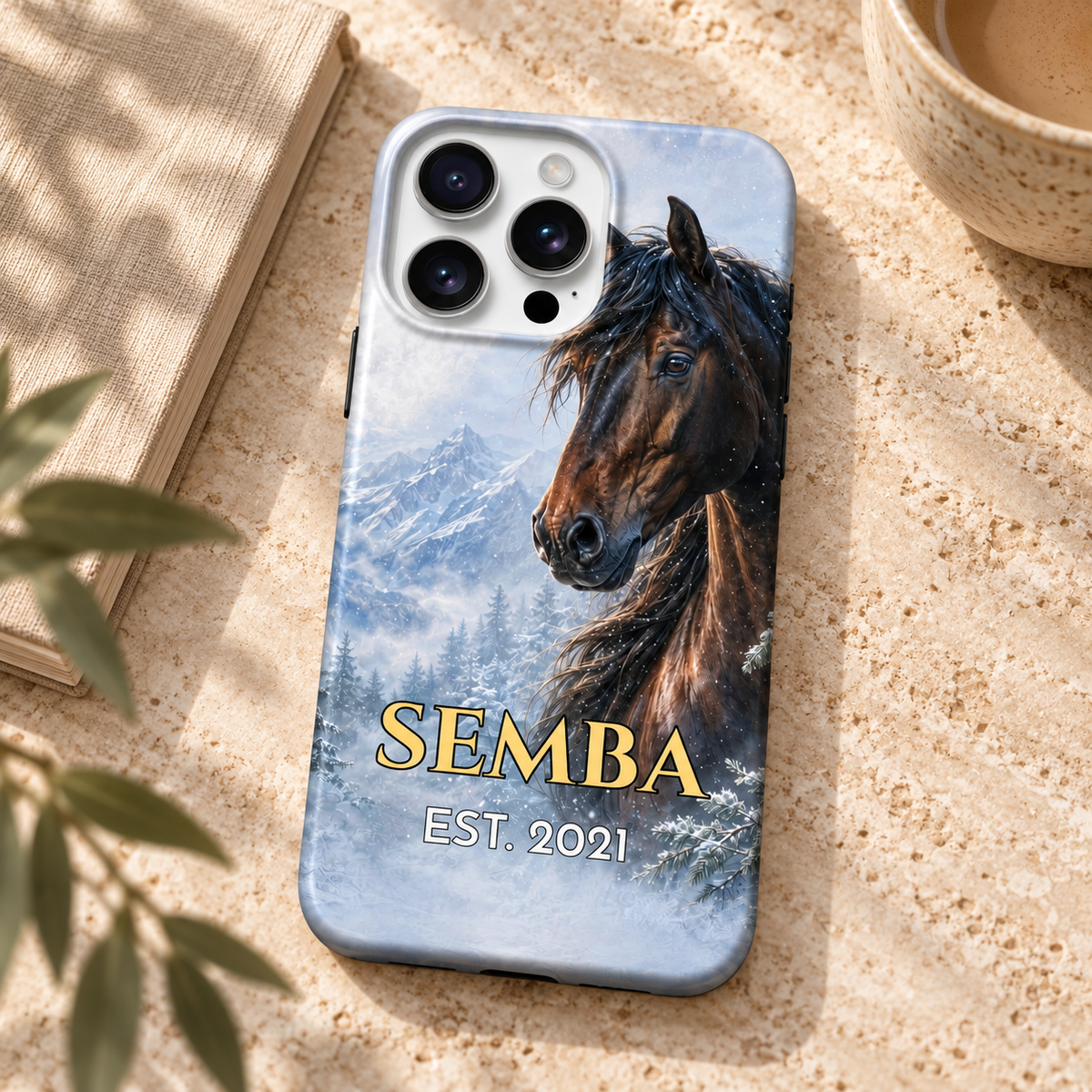 Coque personnalisée cheval d’hiver SEMBA sur une table en travertin près d’un carnet.