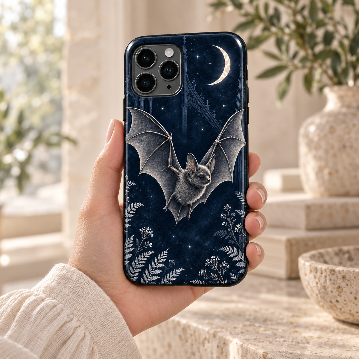 Chauve-souris & Lune — Midnight Blue — coque tenue en main dans un intérieur lumineux