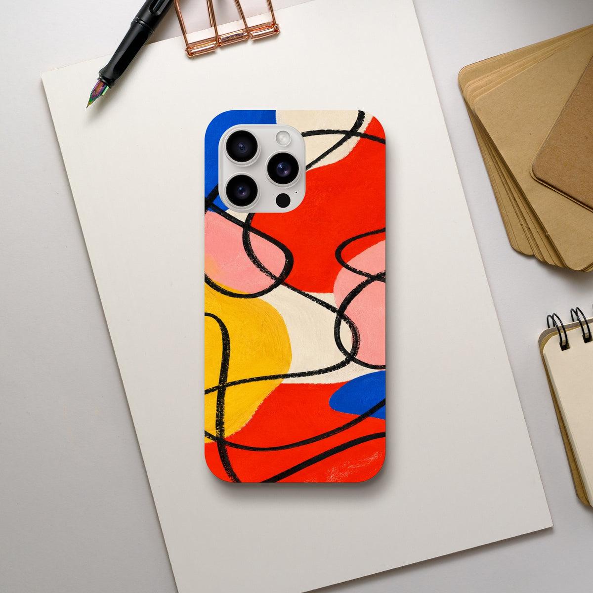 Coque iPhone Éclats géométriques, aplats rouges, jaunes, roses et bleus traversés de lignes noires.