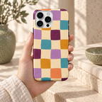 Coque Damier en couleurs tenue en main, motif abstrait imprimé dans un décor naturel crème et sauge.