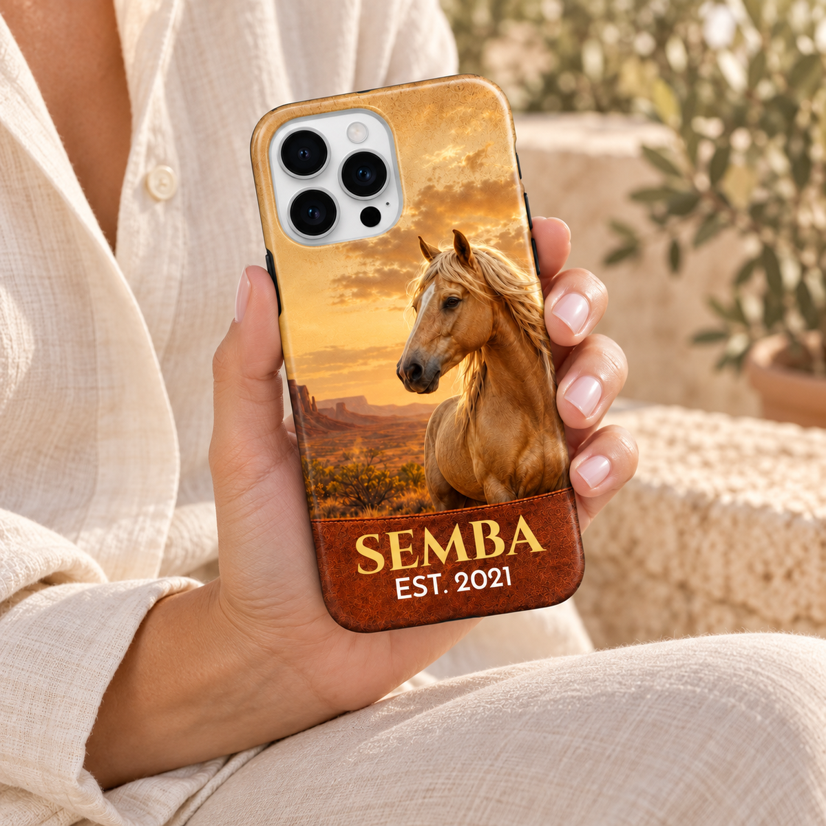 Coque Western personnalisée SEMBA, portrait de cheval doré et coucher de soleil, tenue en main.