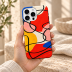 Coque Éclats géométriques tenue en main, dans une lumière naturelle et un décor crème.