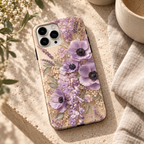 Coque Anémones lavande posée sur une table en travertin clair.
