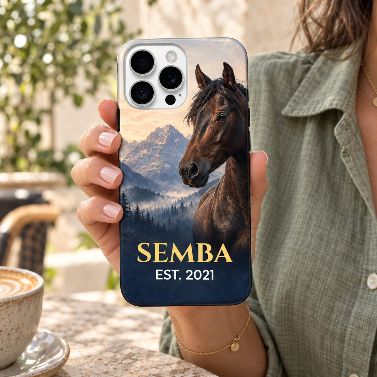 Coque personnalisée cheval des montagnes SEMBA, tenue en main à une terrasse.
