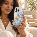 Coque Hortensias bleus tenue en main dans un intérieur lumineux.