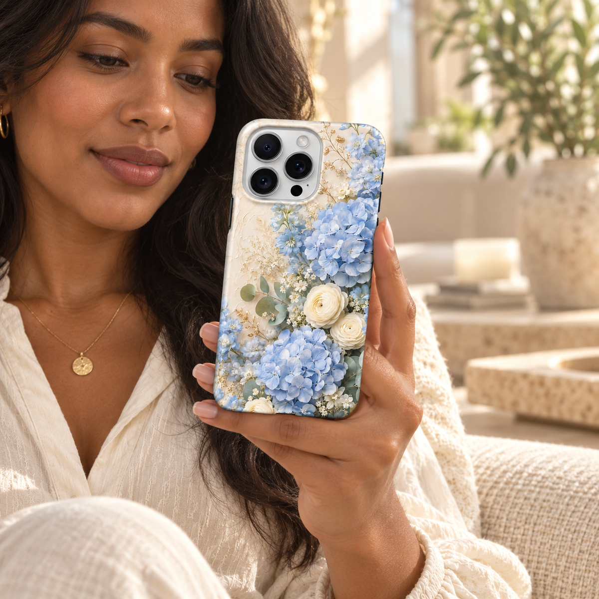 Coque Hortensias bleus tenue en main dans un intérieur lumineux.