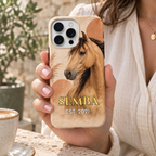 Coque cheval bohème SEMBA, motif crème et terracotta, tenue en main dans un café.