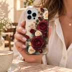Coque Roses bordeaux à fleurs imprimées, tenue en main dans un café.